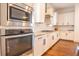 Kitchen features stainless steel appliances, white cabinets, granite countertops, and hardwood floors at 1445 Lettered Olive Ln, Mount Pleasant, SC 29464