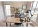 Home office with a large desk, shelving unit, natural light, and neutral carpet at 1445 Lettered Olive Ln, Mount Pleasant, SC 29464