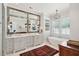 Elegant bathroom with a double vanity, decorative mirror and lighting fixtures, plus a freestanding soaking tub at 1474 Indian St, Mount Pleasant, SC 29464