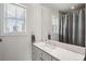 Bathroom featuring a marble countertop, a sink, a window with blinds and shower/tub with curtain at 1474 Indian St, Mount Pleasant, SC 29464
