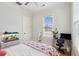 Bright bedroom with a bed topped with a pink patterned coverlet and a desk next to the window at 1474 Indian St, Mount Pleasant, SC 29464