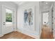 Hallway with hardwood floors, white trim, and view into bedroom with bright light at 1474 Indian St, Mount Pleasant, SC 29464