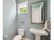 Stylish powder room featuring a pedestal sink, decorative mirror, and blue walls at 1474 Indian St, Mount Pleasant, SC 29464