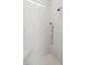 Detail of shower stall with marble-style tiling, rainfall shower head, and built-in seat at 1474 Indian St, Mount Pleasant, SC 29464