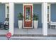 Charming front porch with a red front door, decorative plants, and a cozy seating area, enhancing curb appeal at 176 Clearblue Loop, Summerville, SC 29486