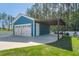 A detached two-car garage with a carport extension, white doors, blue siding, and well-maintained landscaping at 176 Clearblue Loop, Summerville, SC 29486