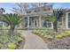 Close-up of the clubhouse exterior featuring rocking chairs on the porch, lush plants, and a welcoming entrance at 2014 Basildon Rd, Mount Pleasant, SC 29466