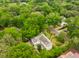 Beautiful aerial view of a traditional home surrounded by lush greenery and mature trees in a charming neighborhood at 2158 Westrivers Rd, Charleston, SC 29412
