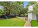 A beautifully landscaped backyard with a pool, outdoor seating and mature trees at 2158 Westrivers Rd, Charleston, SC 29412