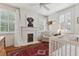 Bright bedroom featuring a fireplace, ceiling fan, two windows, and white wood trim throughout at 2158 Westrivers Rd, Charleston, SC 29412