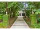 Long driveway leading to a white garage with a flag and lush landscaping at 2158 Westrivers Rd, Charleston, SC 29412