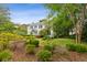 Charming two-story home with lush landscaping, mature trees, and green lawn at 2158 Westrivers Rd, Charleston, SC 29412