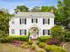 Classic two-story home with white siding, black shutters, manicured landscaping, and a welcoming front entrance at 2158 Westrivers Rd, Charleston, SC 29412