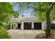 Spacious two-car garage with black doors, red flower pot, and manicured surroundings at 2158 Westrivers Rd, Charleston, SC 29412
