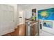 A hallway featuring hardwood floors, white trim, and views into a bathroom and bedroom at 2158 Westrivers Rd, Charleston, SC 29412