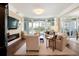 Bright living room boasts hardwood floors, large windows, and a cozy fireplace at 222 S Plaza Ct, Mount Pleasant, SC 29464