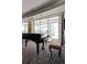 Piano room features a grand piano and beautiful natural light through large windows at 222 S Plaza Ct, Mount Pleasant, SC 29464