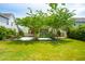 Landscaped backyard featuring green grass, trees, a screened-in porch, and outdoor seating, ideal for relaxation and entertaining at 2254 Show Basket Way, Mount Pleasant, SC 29466