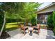 Inviting backyard patio with cushioned chairs and a small table, framed by mature trees and landscaping at 2254 Show Basket Way, Mount Pleasant, SC 29466