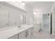 Bright bathroom featuring double vanities, a large mirror, and white cabinets at 2254 Show Basket Way, Mount Pleasant, SC 29466