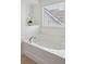 Bathtub with modern fixtures, bright natural light, and alcove shelf with flower decoration at 2254 Show Basket Way, Mount Pleasant, SC 29466