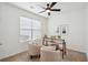Bedroom features ceiling fan, window with blinds, desk, two neutral colored armchairs and carpet at 2254 Show Basket Way, Mount Pleasant, SC 29466