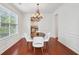 Charming dining room featuring a modern chandelier, white wainscoting, and sleek wood floors at 2254 Show Basket Way, Mount Pleasant, SC 29466