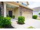 Welcoming front porch with a modern black door, stylish light fixture, and lush greenery at 2254 Show Basket Way, Mount Pleasant, SC 29466
