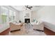 Bright living room features fireplace, ceiling fan, two neutral curved sofas, and an area rug at 2254 Show Basket Way, Mount Pleasant, SC 29466