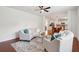 Comfortable living room with ceiling fan, hardwood floors, rug, curved couches, and eat-in kitchen at 2254 Show Basket Way, Mount Pleasant, SC 29466