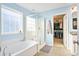 Bright bathroom featuring a glass enclosed shower, soaking tub, and access to the walk-in closet at 2324 Town Woods Rd, Charleston, SC 29414