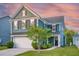 Charming two-story home with blue siding, well-manicured lawn, and attached two-car garage at 2324 Town Woods Rd, Charleston, SC 29414