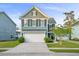 Charming two-story home with blue siding, well-manicured lawn, and attached two-car garage at 2324 Town Woods Rd, Charleston, SC 29414