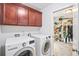 Laundry room with modern appliances, wooden cabinets, and a view of the walk-in closet at 2324 Town Woods Rd, Charleston, SC 29414