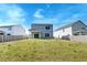 View of the backyard with a grassy hill and neighboring houses in the distance at 239 Parkwood Vista Way, Summerville, SC 29486
