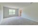 This bedroom features plush carpeting, neutral paint, a large window, and an en-suite bath at 239 Parkwood Vista Way, Summerville, SC 29486