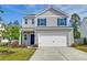 Charming two-story home with gray siding, blue shutters, and a two-car garage under a bright blue sky at 239 Parkwood Vista Way, Summerville, SC 29486