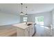 Well-lit kitchen island with pendant lights and stainless steel dishwasher, looking out towards back patio doors at 239 Parkwood Vista Way, Summerville, SC 29486