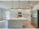 Open kitchen featuring an island with pendant lighting, white cabinetry, stainless steel appliances, and wood floors at 239 Parkwood Vista Way, Summerville, SC 29486