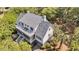 Aerial view of house with balcony, screened porch, lush surrounding trees, and detailed roof at 2624 Jenkins Point Rd, Seabrook Island, SC 29455
