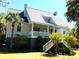 Charming home with a wide porch, manicured lawn, and lush landscaping creating an inviting curb appeal at 2624 Jenkins Point Rd, Seabrook Island, SC 29455