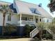 Inviting home featuring a spacious front porch, well-maintained landscaping, and classic architectural details at 2624 Jenkins Point Rd, Seabrook Island, SC 29455