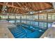 Indoor pool featuring a wood beamed ceiling and a wall of windows to let in plenty of light at 2624 Jenkins Point Rd, Seabrook Island, SC 29455