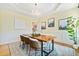 Bright dining room with wood floors, chandelier, tray ceiling, wainscoting, and natural light at 3101 S Shore Dr, Charleston, SC 29407