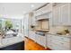 Well-lit kitchen with white cabinets, granite countertops, and stainless steel appliances offers ample workspace at 3101 S Shore Dr, Charleston, SC 29407