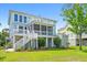 Beautiful two-story home exterior with porch, balcony, manicured lawn and tasteful landscaping at 3101 S Shore Dr, Charleston, SC 29407