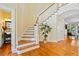Traditional staircase design with decorative tree and beautiful hardwood floors at 3101 S Shore Dr, Charleston, SC 29407