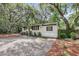 Charming home with a green front door and well-maintained landscaping, enhanced by gravel driveway and mature trees at 3293 River Rd, Johns Island, SC 29455