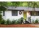 Close-up of the house with black and white trim and a vibrant green door with matching wreaths at 3293 River Rd, Johns Island, SC 29455