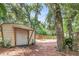 Backyard shed providing extra storage space, complemented by a large yard and mature trees at 3293 River Rd, Johns Island, SC 29455